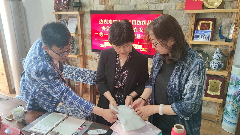 曲總向朱會(huì)長(zhǎng)展示面料